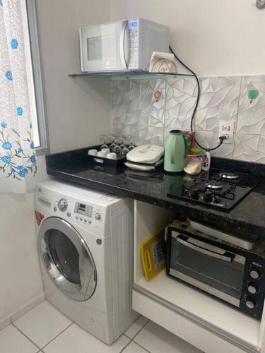 a kitchen with a washing machine and a microwave at Apartamento térreo próximo ao Shopping Iguatemi in Votorantim