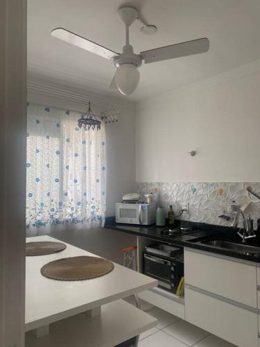 a kitchen with a table and a ceiling fan at Apartamento térreo próximo ao Shopping Iguatemi in Votorantim