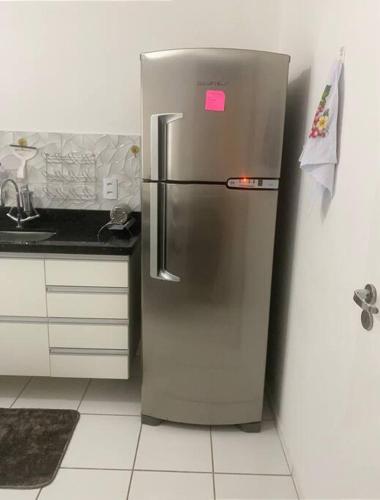 a stainless steel refrigerator with a pink sticker on it at Apartamento térreo próximo ao Shopping Iguatemi in Votorantim