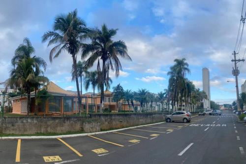 a car driving down a street with palm trees at Apartamento térreo próximo ao Shopping Iguatemi in Votorantim