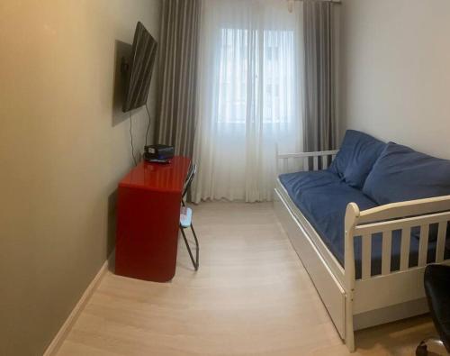ein kleines Schlafzimmer mit einem Bett und einem roten Tisch in der Unterkunft Apartamento térreo próximo ao Shopping Iguatemi in Votorantim