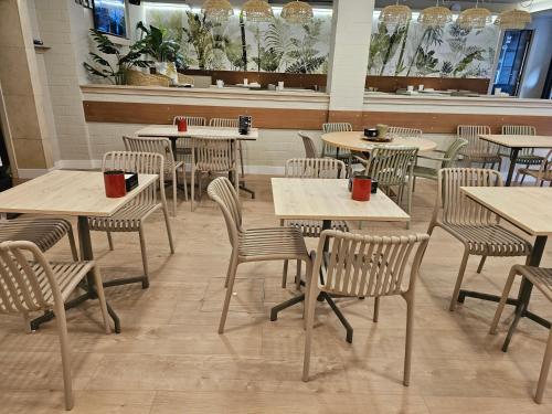 una sala da pranzo con tavoli e sedie con tazze rosse sopra di Hotel Mariquito a Finisterre