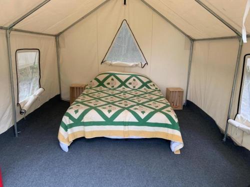 een slaapkamer met een bed in een tent bij Sweet Hill Glamping in Rhinebeck