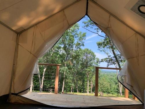 a tent with a view of a forest at Sweet Hill Glamping in Rhinebeck