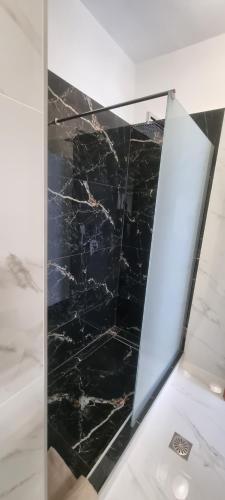 a black marble floor in a room with a mirror at Ellis-Suites Nea Peramos Kavala in Nea Peramos