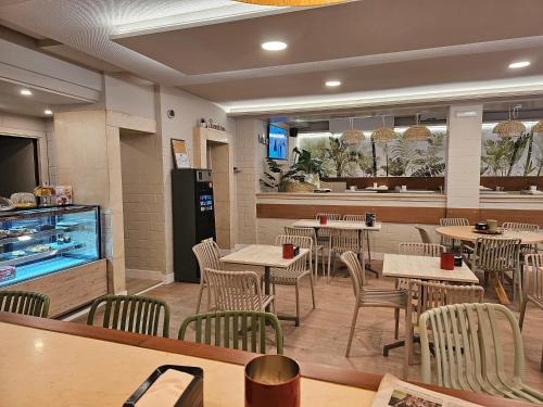 a restaurant with tables and chairs and a counter at Hotel Mariquito in Finisterre