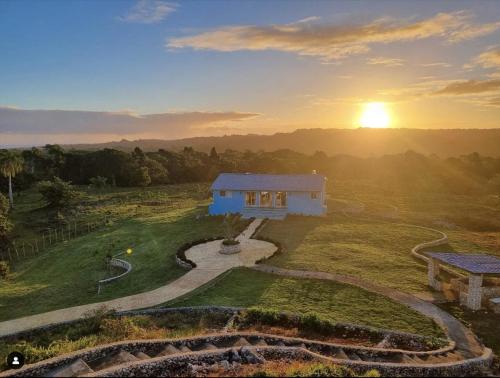 a house on a hill with the sunset in the background at Finca Jasmat in Cabrera
