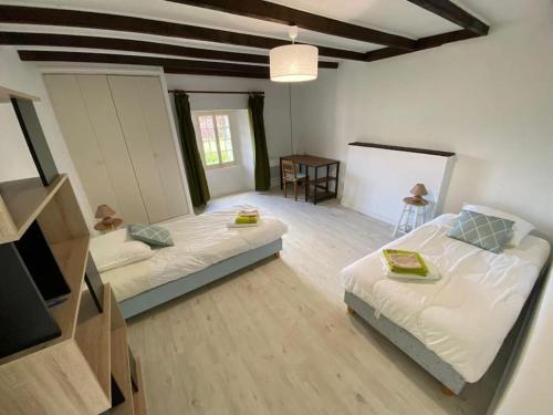Großes Zimmer mit 2 Betten und einem TV. in der Unterkunft Gîte au coeur de la campagne normande in Ouville