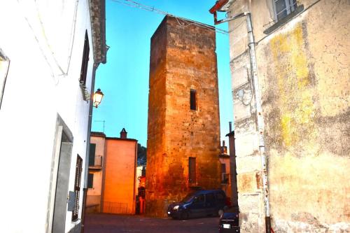an old brick tower in the middle of a street at La Casetta sotto la Torre in Lubriano