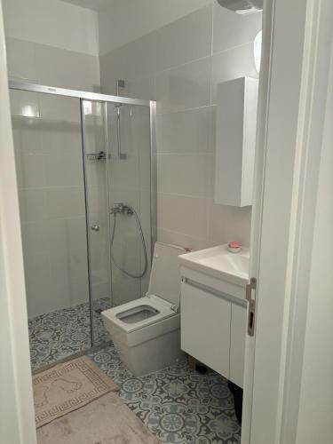 a white bathroom with a shower and a toilet at Caesar Resort SPA in Iskele