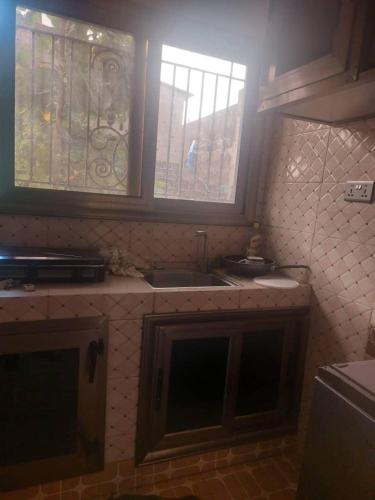 una cocina con fregadero y una ventana. en Castor, en Ziguinchor
