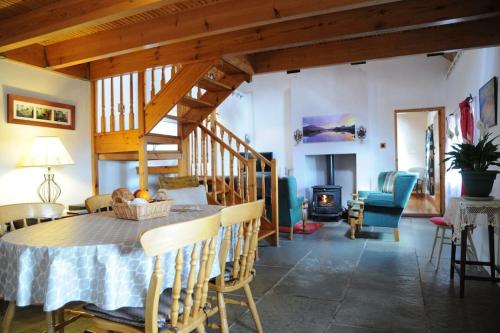comedor con mesa, sillas y chimenea en Cottage Skelligs Coast, Ring of Kerry, en Cahersiveen