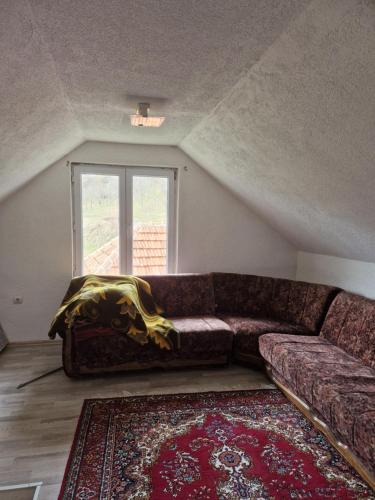 a couch in a living room with a window at Mountain Home Paravci in Čajniče