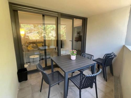 a dining table and chairs in a room with a patio at Nuevo, espacioso y confortable con pkg y piscina in Tossa de Mar