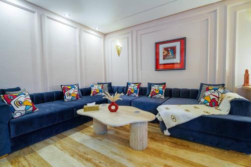 een woonkamer met een blauwe bank en een tafel bij DarSublime au cœur de Marrakech Jacuzzi privé in Marrakesh