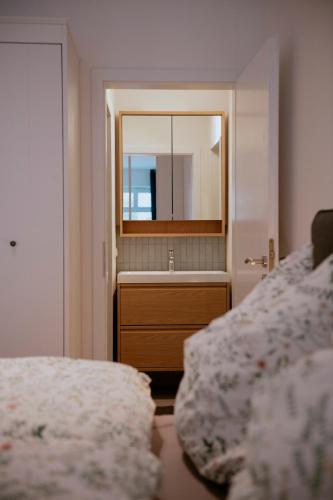 a bedroom with a mirror and a bed and a sink at Charmante Ferienwohnung in der Altstadt in Landsberg am Lech
