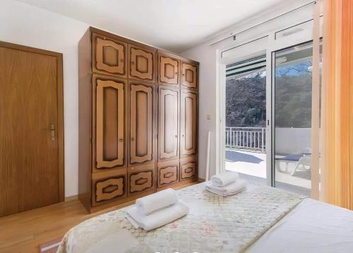 a bedroom with a large bed with two white towels on it at Apartman Vesna in Opuzen