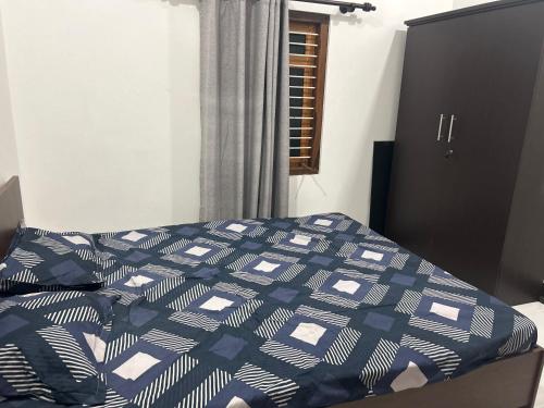 um quarto com uma cama com um edredão azul e branco em Ithaya Illam em Point Pedro