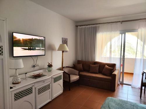 salon z kanapą i telewizorem z płaskim ekranem w obiekcie Domina Coral Bay w Szarm el-Szejk