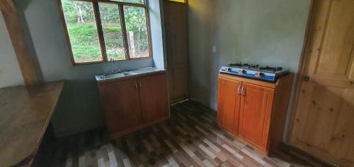 una cocina vacía con fogones y ventana en Options house, en Bijagua