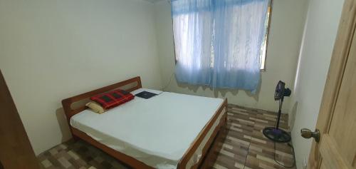 een klein bed in een kamer met een raam bij Options house in Bijagua