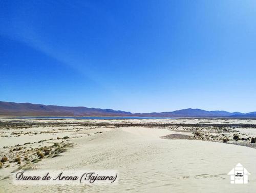 a sandy desert with a house in the middle of it at Departamento Rustico 1 in Tarija
