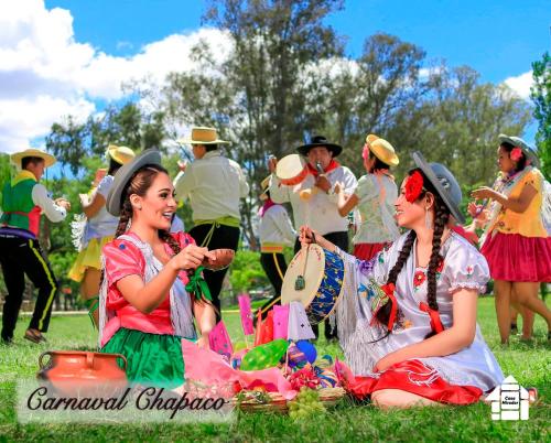 a group of people in costumes sitting in the grass at Departamento Rustico 1 in Tarija