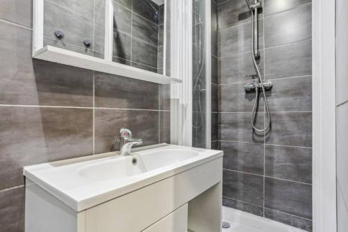 une salle de bain avec un lavabo et une douche dans l'établissement Charmant studio Montorgueil, à Paris