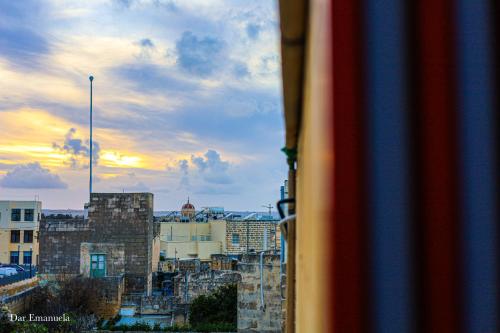 a view from a window of a city at sunset at 150 years old Maltese Townhouse: Dar Emanuela in Cospicua