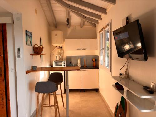 a small kitchen with a table and a microwave at Bungalow jardin tropical - piscine in Saint-François