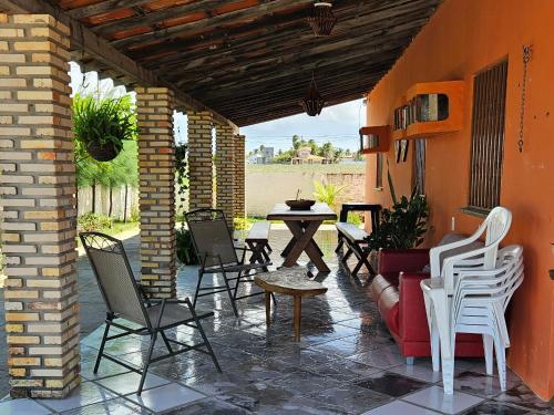 a patio with chairs and a table and a table at Casa ampla e agradável no Barramares, Luis Correia in Luis Correia