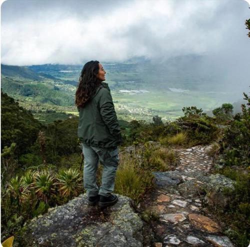 a woman standing on a rock on a mountain at Alojamiento/Lodging:El Indio Ese in Sopo