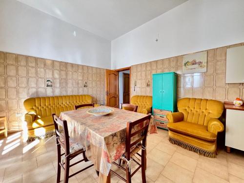 a dining room with a table and yellow chairs at Casa per vacanze Ludovica in Avetrana
