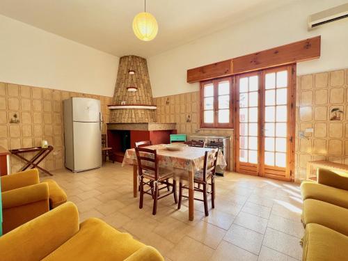 een keuken met een tafel en een koelkast bij Casa per vacanze Ludovica in Avetrana