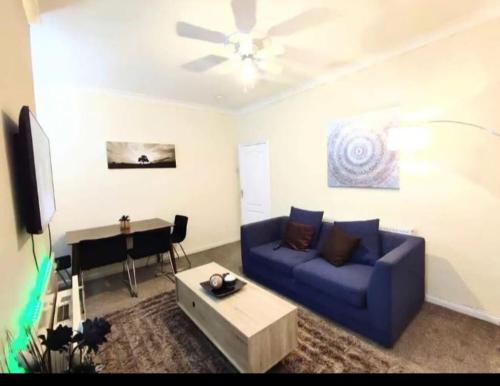 uma sala de estar com um sofá azul e um piano em Cozy Room Close to City Center em Old Walker