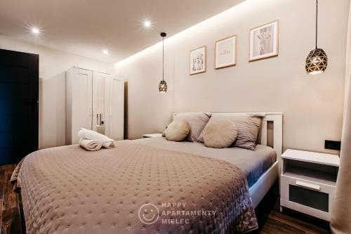 biała sypialnia z łóżkiem z poduszkami w obiekcie Happy Place - Happy Apartamenty Mielec w Mielcu