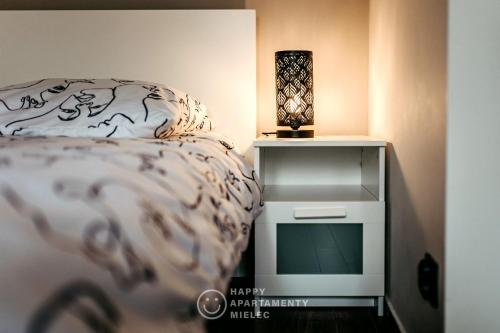 a bedroom with a bed and a night stand with a television at Happy Place - ApartamentyHappy pl in Mielec