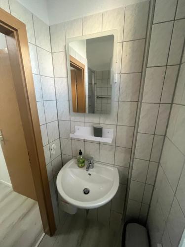 a bathroom with a white sink and a mirror at Pension Christianstraße in Bernburg
