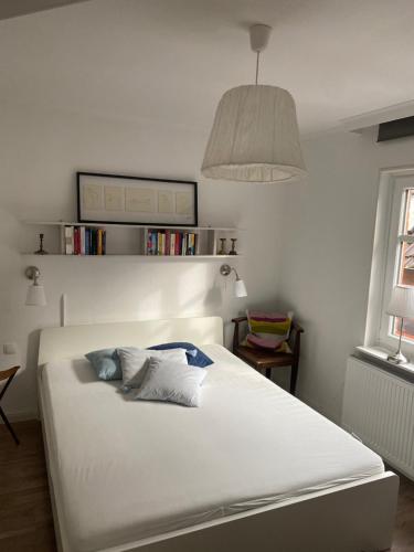 ein Schlafzimmer mit einem großen weißen Bett mit einer Lampe in der Unterkunft Ferienwohnung am Kalkberg in Bad Segeberg