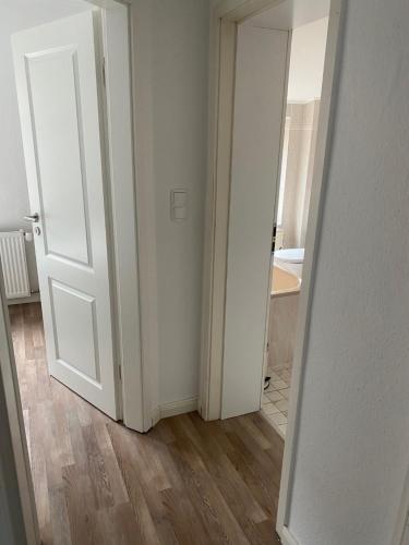 an empty room with a white door and wooden floors at Ferienwohnung am Kalkberg in Bad Segeberg