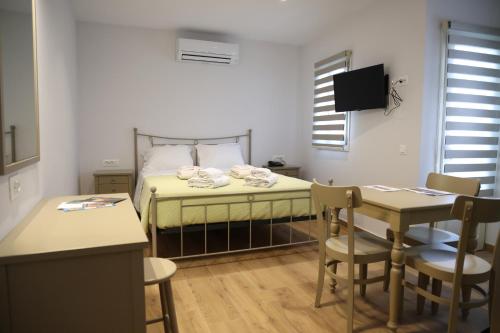 Schlafzimmer mit einem Bett, einem Tisch und Stühlen in der Unterkunft Lythri Studios in Chios