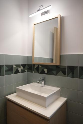 a bathroom with a white sink and a mirror at Lythri Studios in Chios