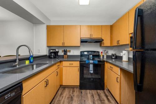 a kitchen with wooden cabinets and a black appliance at Family condo near Lettuce Lake in Tampa
