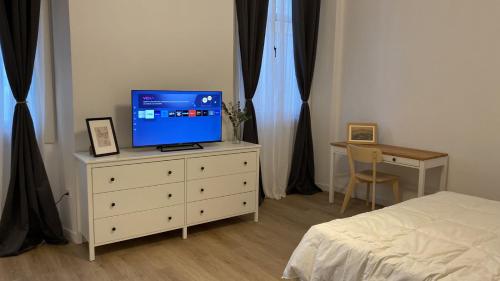1 dormitorio con cama y vestidor con TV en Suites Larios en Málaga