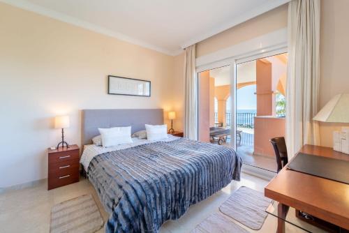 a hotel room with a bed and a desk and a balcony at Beachside villa with panoramic sea views in Benalmádena