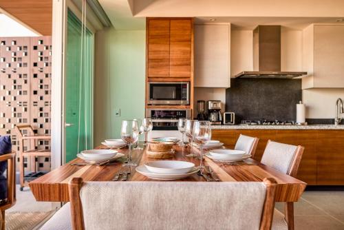 a wooden table with glasses and plates on it in a kitchen at Luxurious Penthouse in Puerto Vallarta in Puerto Vallarta