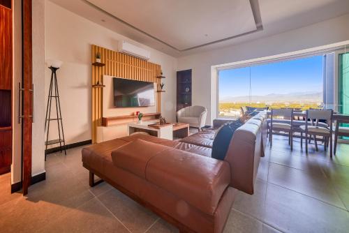 - un salon avec un canapé brun et une salle à manger dans l'établissement Luxurious Penthouse in Puerto Vallarta, à Puerto Vallarta