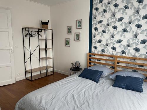 um quarto com uma cama com almofadas azuis em Parfait pour visiter ou travailler près de Paris em Clamart