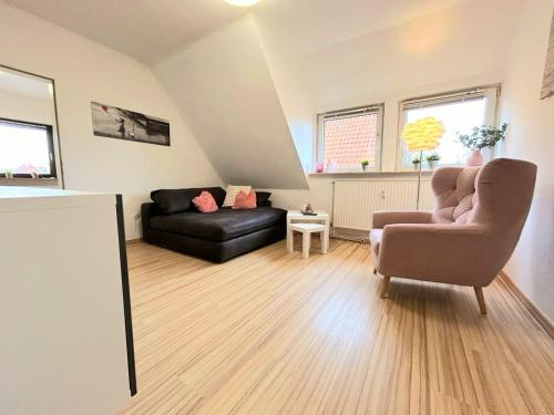 a living room with a couch and a chair at Ferienwohnung Wilhelm in Steyerberg