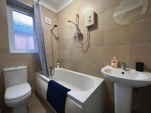 a bathroom with a sink and a tub and a toilet at Cosy 4-Bed House in Manchester in Manchester